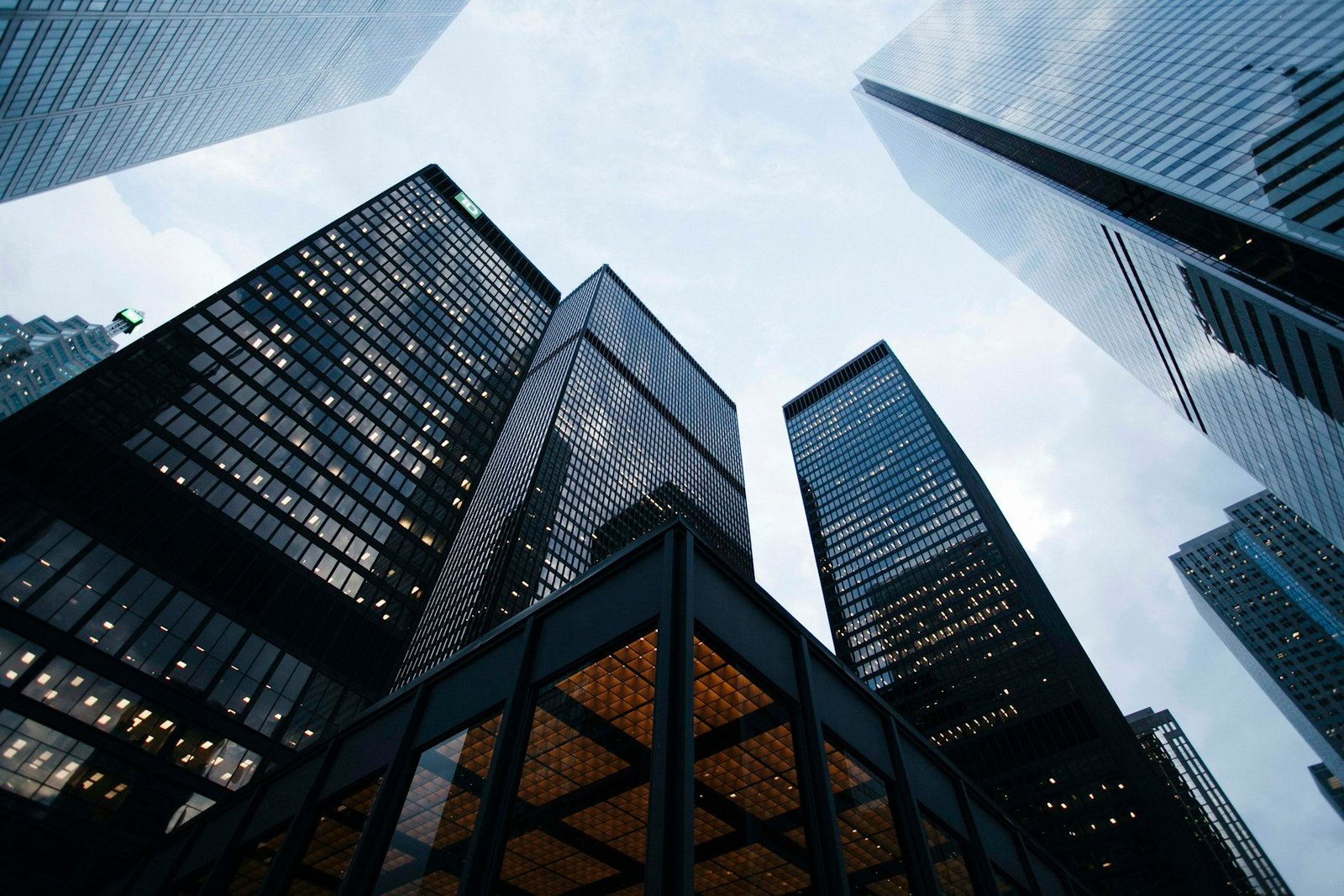 Tall commercial buildings seen from ground level against a pale sky