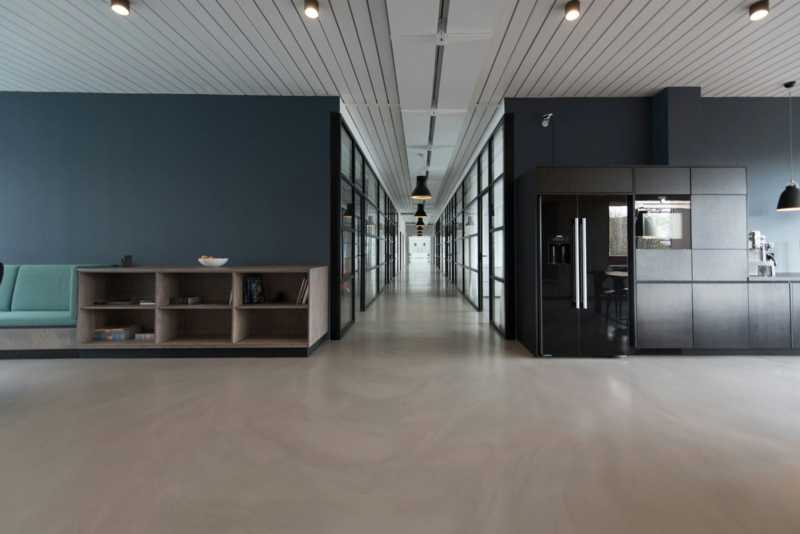Long empty professional interior with a distant doorway, photographed from far back