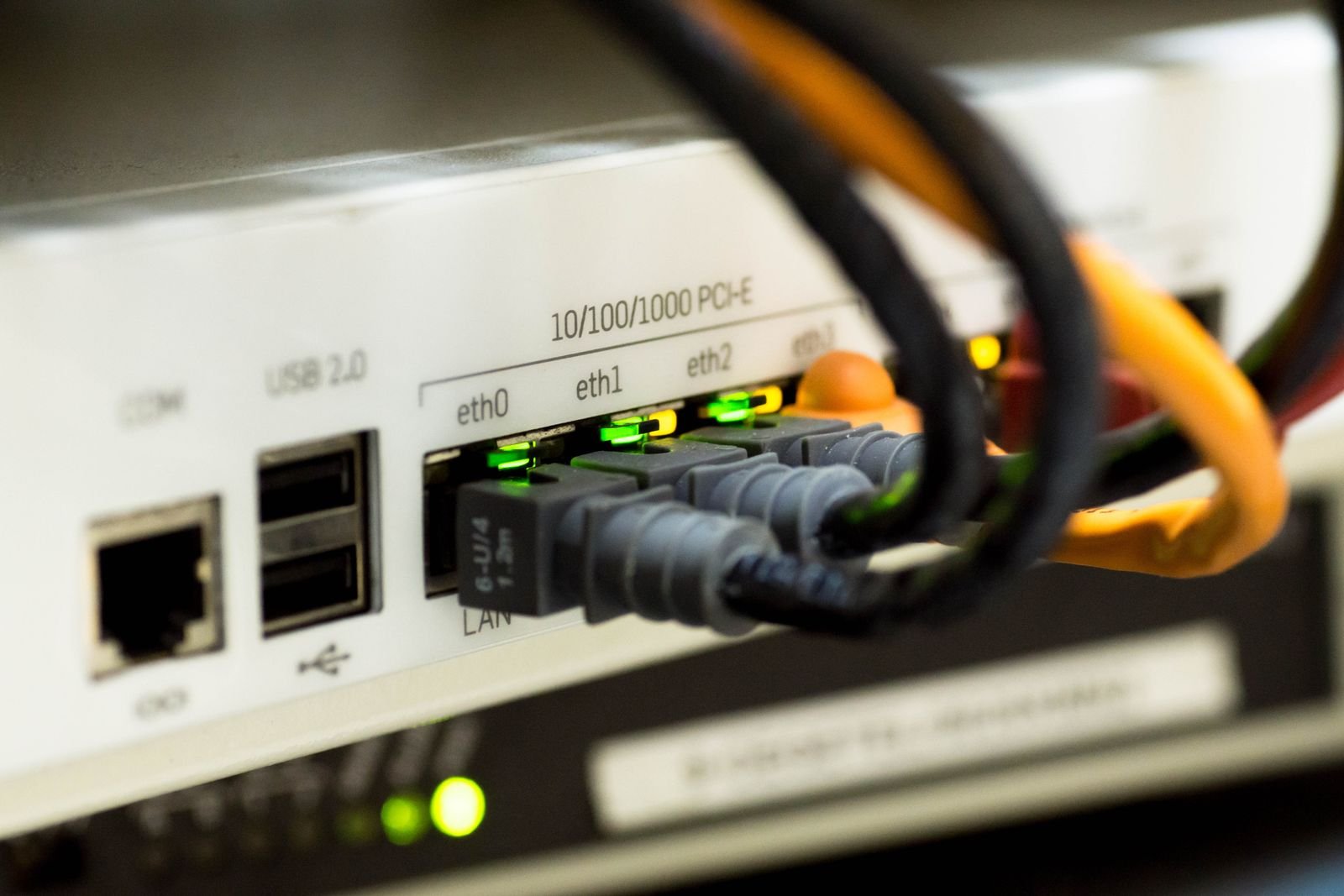 Close crop of labelled network ports and fibre connectors on communications hardware