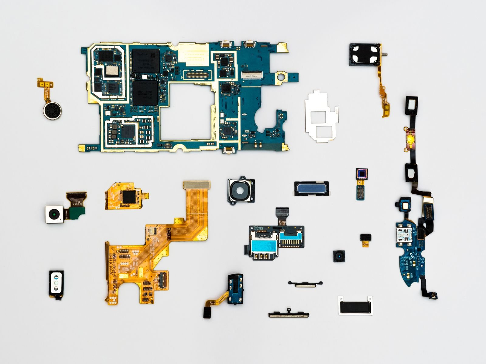 Disassembled electronic components laid out as isolated parts on a pale surface